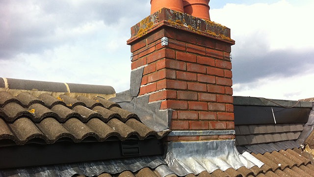 Brick chimney on a clay tile roof